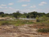 Afloramento em primeiro plano e lagoa em segundo plano com a presença de vegetação típica da caatinga